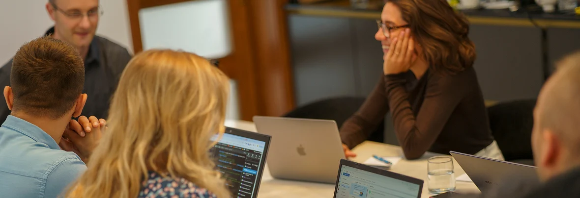 Team der SEO Revolution arbeitet konzentriert an Laptops in einem Meetingraum.